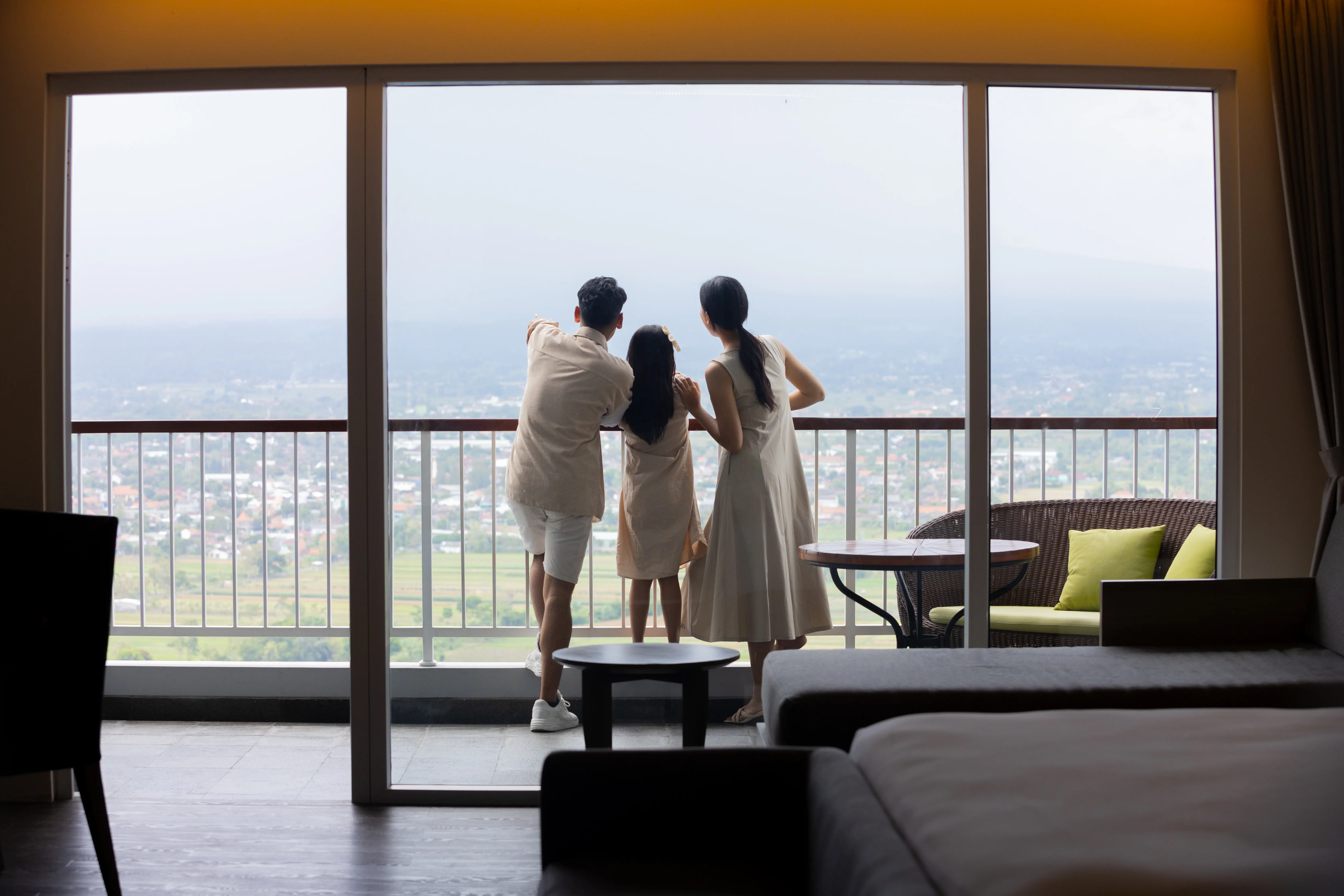 Keluarga menikmati view kota Yogyakarta dari balkon kamar di Amaranta Prambanan, hotel bintang 5 terbaik di Jogja